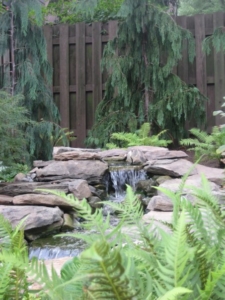 A natural looking waterfall completes the landscaping of this backyard