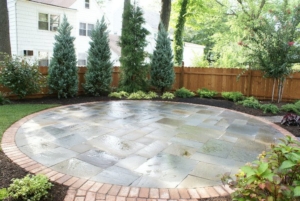 A beautiful stone and brick circular patio in a Maplewood NJ backyard