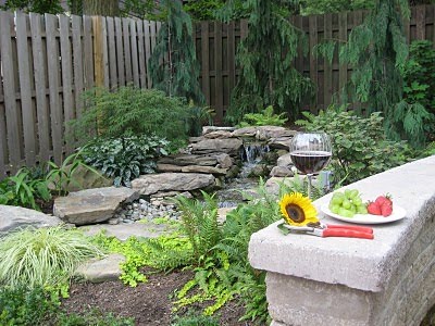A natural looking waterfall completes the landscaping of this backyard