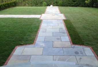 Custom Blue Stone Walkway surrounded by green grass in a landscape designed by GA Landscape Design