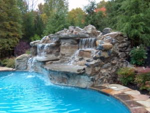 Custom Waterfall into a pool surrounded by large plantings in this Scotch Plains NJ backyard