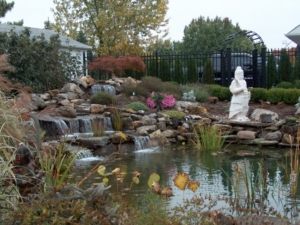 A large water feature completes the landscape design of this backyard