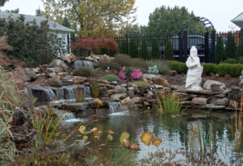 A large water feature completes the landscape design of this backyard