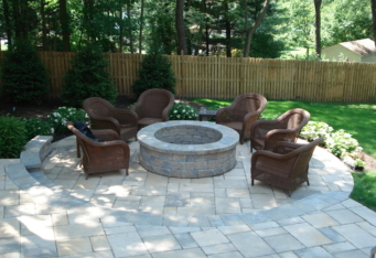 Custom Fire Pit with seating complete this backyard landscape design in Clinton NJ