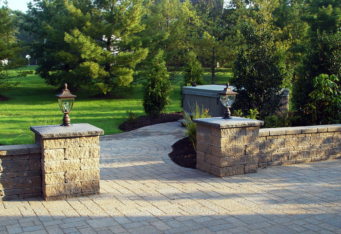 Paver wall with Columns and Lighting complete the entrance to the hot tub in this landscape